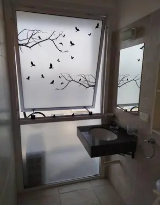 a bathroom with a window with birds on the wall at Departamento in Cordoba