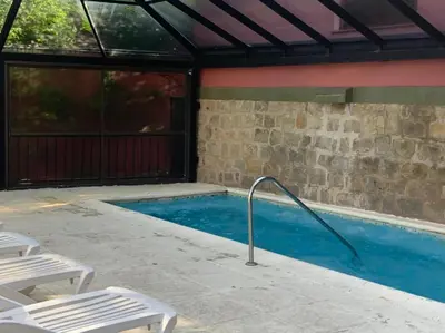 a swimming pool with a metal rail next to a building at Hotel Tanti Spa & Resort in Tanti
