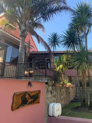 a house with palm trees in front of it at Hotel Tanti Spa & Resort in Tanti