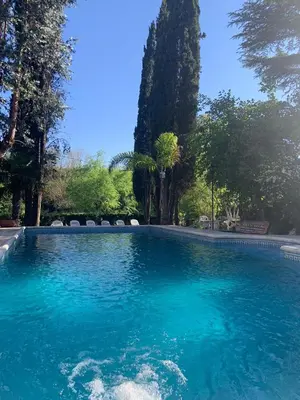 a swimming pool with blue water in a yard at Hotel Tanti Spa & Resort in Tanti