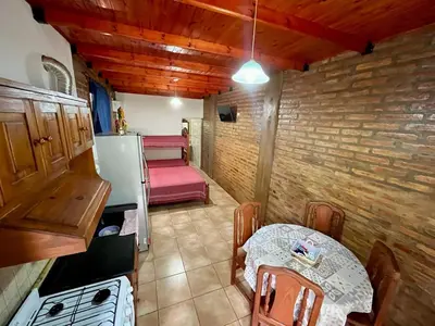 a small kitchen with a table and a refrigerator at Departamentos La Morita in Embalse