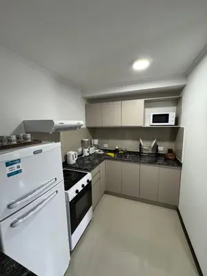 a kitchen with a white refrigerator and a stove at Complejo Venetto Village in Villa Parque Siquiman