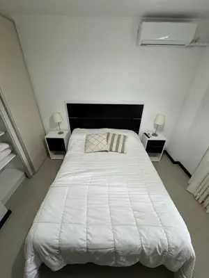 a white bed in a room with two night stands at Complejo Venetto Village in Villa Parque Siquiman