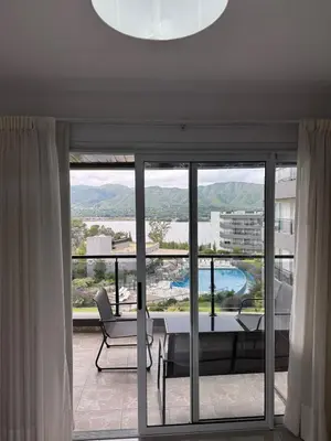 a living room with a table and chairs and a large window at Complejo Venetto Village in Villa Parque Siquiman