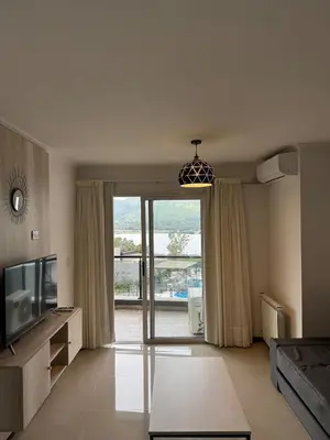a living room with a tv and a sliding glass door at Complejo Venetto Village in Villa Parque Siquiman