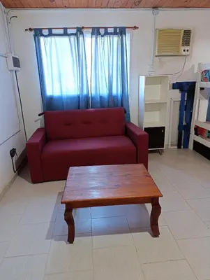 a living room with a red couch and a coffee table at Rio Segundo Colo 5 in Río Segundo