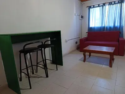 a living room with a red couch and two bar stools at Rio Segundo Colo 5 in Río Segundo