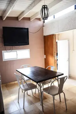 a dining room table with chairs and a tv on a wall at Rio Segundo Colo 5 in Río Segundo