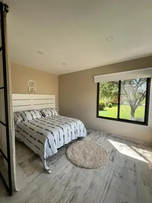 a bedroom with a bed and a large window at LA VALENTINA casa de campo in Villa Cura Brochero