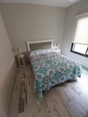 a bedroom with a bed with a floral bedspread on it at LA VALENTINA casa de campo in Villa Cura Brochero