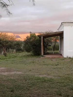 a house with a porch with mountains in the background at LA VALENTINA casa de campo in Villa Cura Brochero