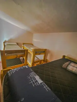 a room with three beds and two chairs in it at Hostel La Resolana in Villa Alpina