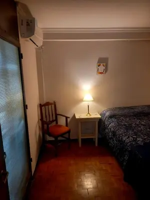 a bedroom with a bed and a chair and a lamp at Balcon2k in Cordoba