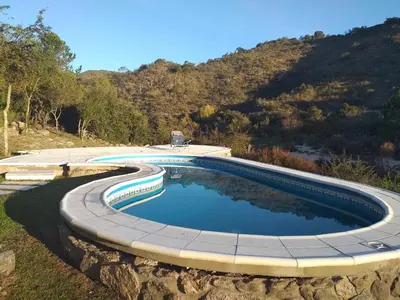 a swimming pool with a stone wall around it at Lagriega in Cuesta Blanca