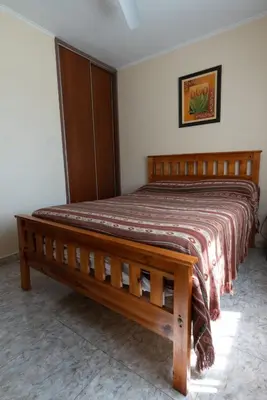 a bed in a bedroom with a wooden bed frame at Cabañas La Casita de Fran in Villa del Dique