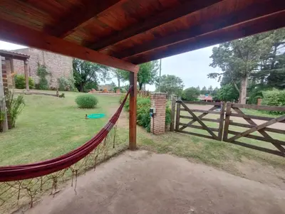 a porch with a hammock and a fence at Cabañas La Casita de Fran in Villa del Dique