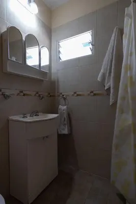 a bathroom with a sink and a mirror and a shower at Cabañas La Casita de Fran in Villa del Dique