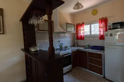 a kitchen with a stove and a white refrigerator at Cabañas La Casita de Fran in Villa del Dique