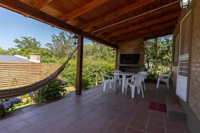 a patio with a hammock and a table and chairs at Cabañas La Casita de Fran in Villa del Dique