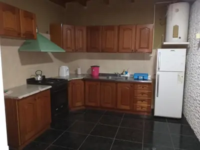 a kitchen with wooden cabinets and a white refrigerator at Mateo y Stella in Bialet Massé
