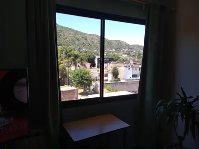 a window in a room with a view of a city at Deptos Carlos Paz A in Villa Carlos Paz