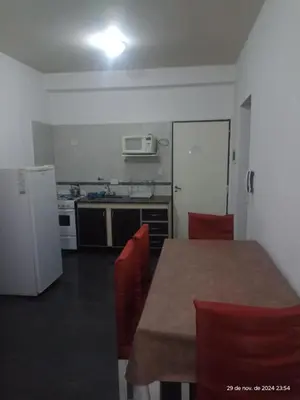 a kitchen with a table and a white refrigerator at Deptos Carlos Paz B in Villa Carlos Paz