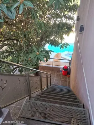 a set of stairs leading up to a building with trees at Departamento en la Villa in Villa Carlos Paz