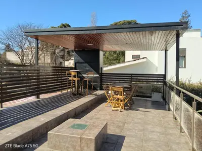 a patio with tables and chairs on a building at Departamento en la Villa in Villa Carlos Paz