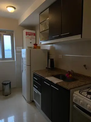a kitchen with a white refrigerator and a sink at Departamento barrio cerrado en altura in Cordoba