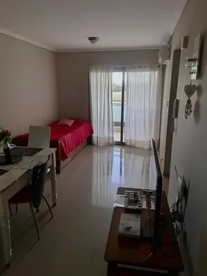 a room with a bed and a desk with a computer at Departamento barrio cerrado en altura in Cordoba