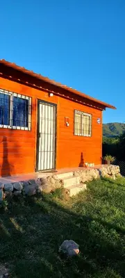 an orange house with a grassy yard in front of it at Mateo y Stella 2 in Bialet Massé