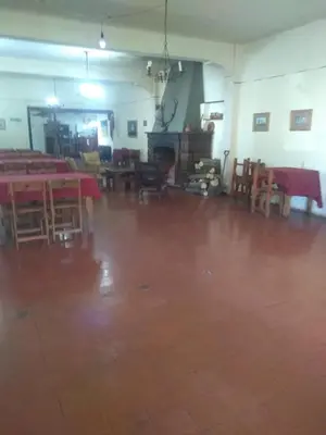 an empty room with tables and chairs and a floor at Hosteria Calamuchita in Villa del Dique