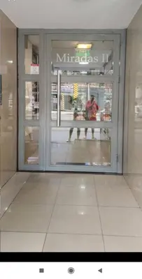 a reflection of a person walking in the window of a store at La Terraza in Cordoba