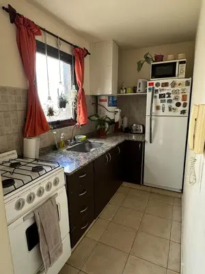 a kitchen with a white refrigerator and a stove top oven at Departamento con Balcón y Asador in Río Cuarto