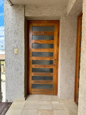 a wooden door on the side of a building at Departamento con Balcón y Asador in Río Cuarto