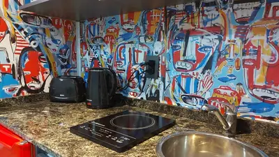 a kitchen with a counter with a sink and a wall covered in graffiti at Espectacular departamento en el centro 301 in Cordoba