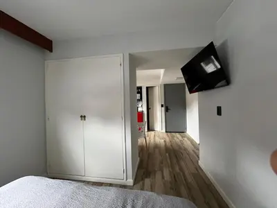 a bedroom with a white cabinet and a television on the wall at Espectacular departamento en el centro 301 in Cordoba