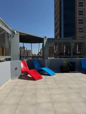 two red and blue chairs sitting on a rooftop at Espectacular departamento en el centro 301 in Cordoba