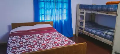 a bedroom with two bunk beds with blue curtains at Cabaña La Resolana in Villa Alpina