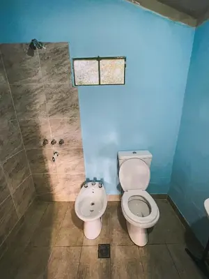 a bathroom with a toilet and a shower at Cabaña La Resolana in Villa Alpina