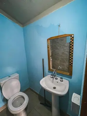 a bathroom with a white toilet and a sink at Cabaña La Resolana in Villa Alpina