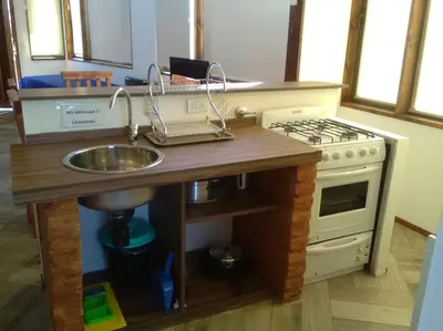 a kitchen with a sink and a stove at Cabañas Amanecer en Los Molinos in La Estancia