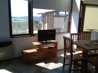 a living room with a table and a television on a stand at Cabañas Amanecer en Los Molinos in La Estancia