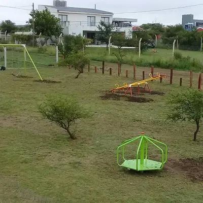 a park with two play equipment in the grass at Cabañas Amanecer en Los Molinos in La Estancia