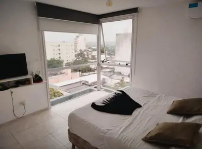 a bedroom with a bed and a large window at Departamento 1 dormitorio in Cordoba