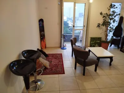 a living room with a table and chairs and a room with a snowboard at Departamento 1 dormitorio in Cordoba