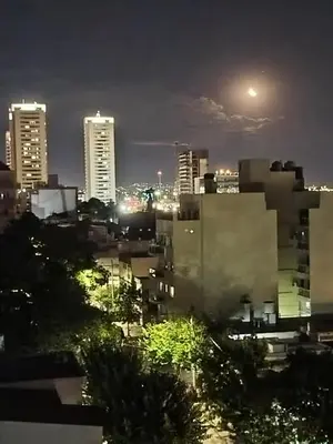 a city lit up at night with tall buildings at Departamento 1 dormitorio in Cordoba