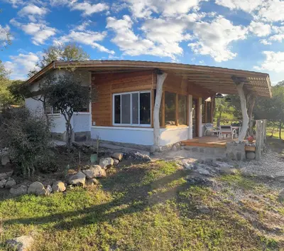 a small cabin with a porch in a field at Rio Dorado Resort in Cavalango