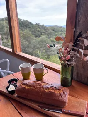 a wooden table with a loaf of bread and two cups at Rio Dorado Resort in Cavalango