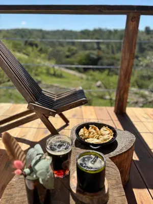 a table with a plate of food and two glasses of beer at Rio Dorado Resort in Cavalango